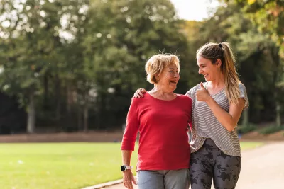 Oma und Tochter laufen durch den Park